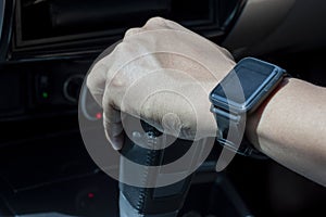 Hand holding automatic transmission lever while driving.