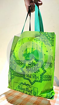 Hand holding a bag of idul Fitri parcels, Indonesian tradition of sharing food before Eid arrives