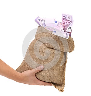 Hand holding bag with many banknotes