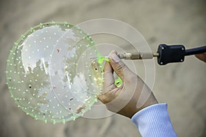 Hand holding a balloon and inflate with a needle