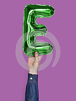 Hand holding balloon letter E