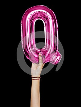 Hand holding balloon letter Q