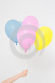 Hand holding balloons. Holiday concept. Colorful party balloons background. on white. Copy space