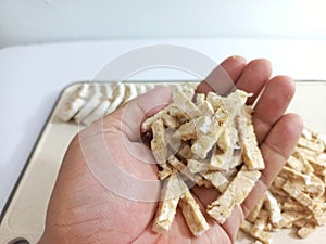 Hand holding batonnet-cut tempeh