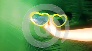 Hand holding big sunglasses, vacation, travel, vacation, template on a green background. Human hand, modern video background