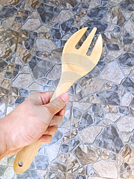 Hand holding big wooden fork