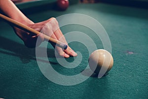 Hand holding billiard stick cue ready to shot ball