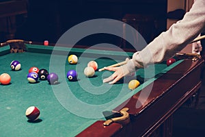 Hand holding billiard stick cue ready to shot ball