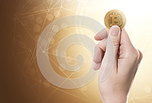 Hand holding a Bitcoin Cash coin on a bright background with blockchain network. Copy space included.