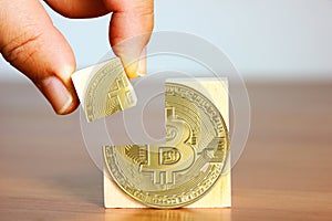 Hand holding bitcoin jigsaw putting down on bitcoin pattern