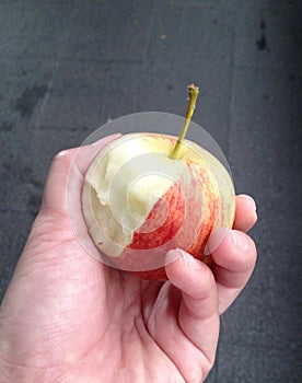 Hand holding biten red apple, healthy fruit concept