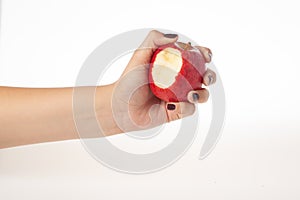Hand holding bitten red apple isolated on white background