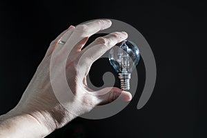 Hand holding a black bulb isolated