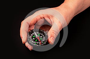 Hand holding the black compass isolated