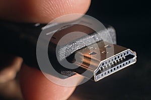 Hand holding black HDMI cable. Man's hand holds a HDMI Connector. Closeup HDMI cable.