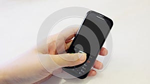 Hand holding a black old fashioned mobile phone with dial pad