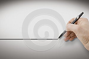 Hand holding a black pencil drawing a perfectly straight black line on white background