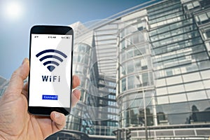 Hand holding a black smartphone with button connect to wireless internet hotspot on screen