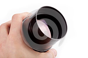 Hand holding a black unbranded clean camera photo lens closeup. Glass light reflections photography abstract concept