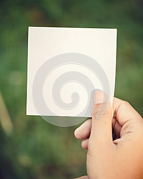 hand holding blank paper on nature background