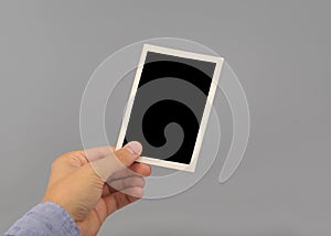 Hand holding blank photo frame