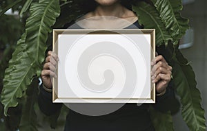 Hand Holding Blank Photo Frame for Design Mockup Template in the garden