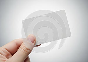 Hand holding a blank, rectangular white card against a neutral