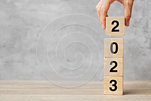 Hand holding block 2023 text on table. Resolution, strategy, plan, goal, motivation, reboot, business and New Year holiday