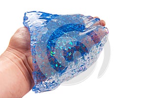 Hand holding a blue glitter slime isolated on white background