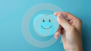 a hand holding a blue paper cut-out of a happy smiley face, symbolizing positive thinking. Ai Generated