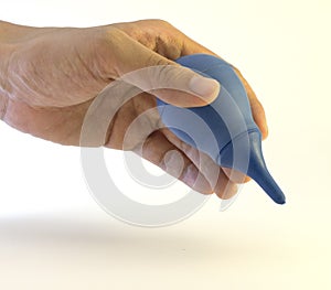 A hand holding blue rubber nasal aspirator
