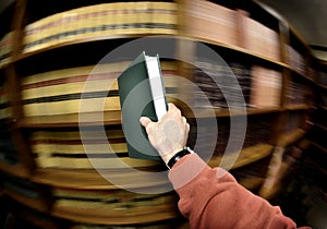 Hand Holding Book in Library