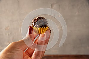 Hand holding Brazilian bonbon Brigadeiro photo