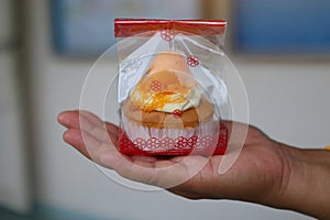 Hand holding bread Foi Thong Cake Fios de ovos put in plastic bags, home-made sweets, photo