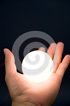 Hand holding a bright ball