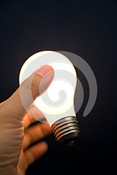 Hand holding a Bright Light Bulb