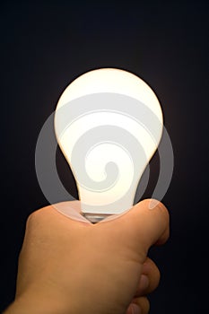 Hand holding a Bright Light Bulb