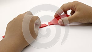 Hand holding a broken red plastic spoon