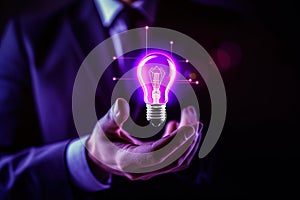 Hand holding bulb. Businessman holding a bright light bulb. Concept of Ideas.