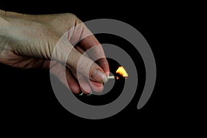 Hand holding burning match stick