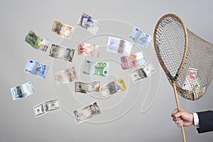 Hand Holding Butterfly Net With Flying Banknotes