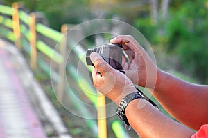 Hand holding camera photograph in nature background