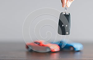 Hand holding car keys and a remote control for keyless entry. Car loan, contract agreement, buying and rent car concept, Sale