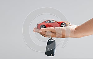 Hand holding car keys and a remote control for keyless entry. Car loan, contract agreement, buying and rent car concept, Sale