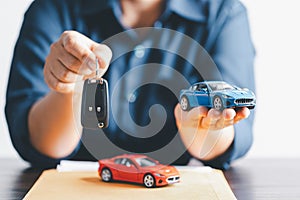 Hand holding car keys and a remote control for keyless entry. Car loan, contract agreement, buying and rent car concept, Sale