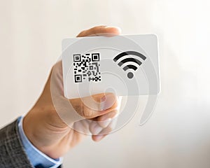 Hand holding card with qr code and wifi symbol