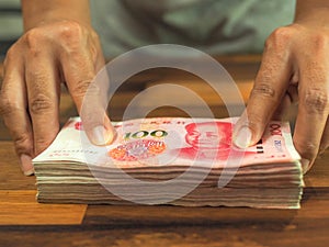 Hand holding cash yuan, Bundle of Chinese one hundred Yuan banknotes