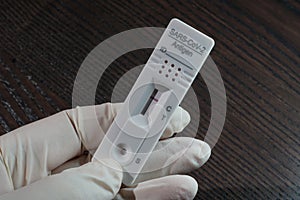 A hand holding the cassette of a negative rapid antigen SARS-CoV-2 test