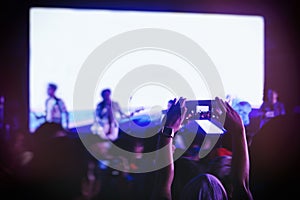 Hand holding Cell phone Blank screen Photo shot Blur Concert Background