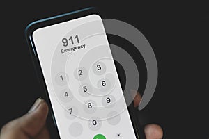 Hand holding cell phone with emergency number 911